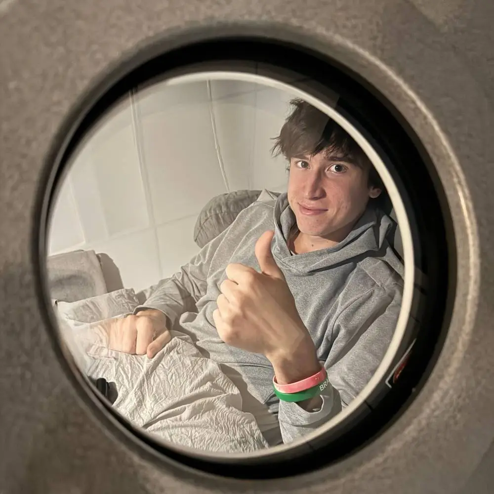 Young man in hyperbaric chamber giving a thumbs up