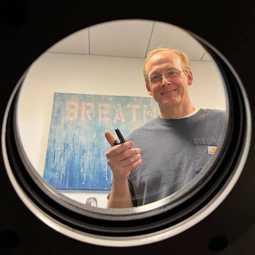 Hyperbaric technician smiling into chamber